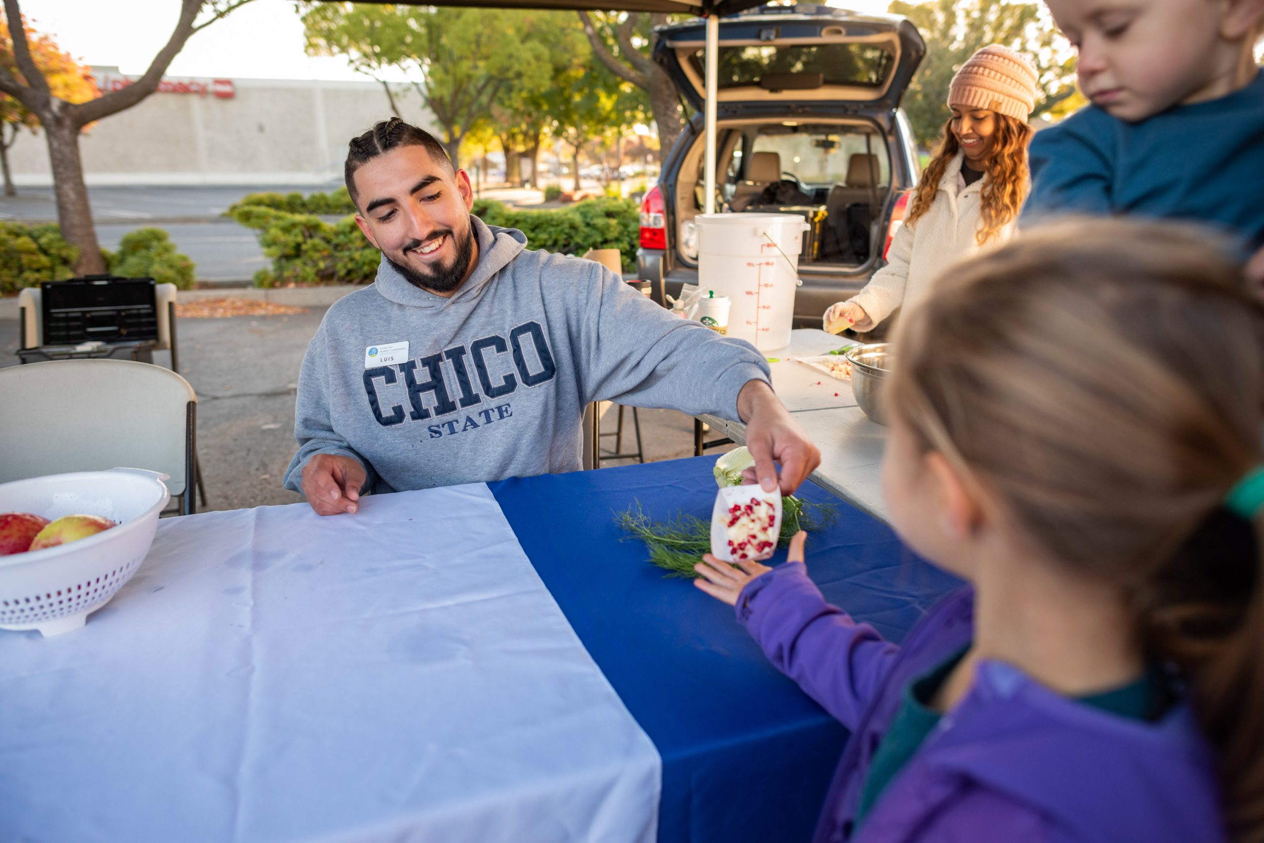 A CHC staff member giving away healthy food samples at a farmers market in Chico CA.